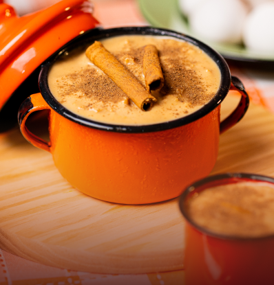 Panela esmaltada laranja com ambrosia e paus de canela